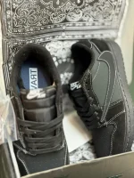 کتونی جردن 1 ترویس اسکات بلک فانتوم با لوگوی معکوس نایکی و رنگ‌بندی مشکی و سفید