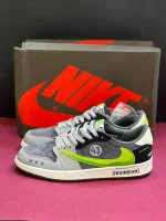 کتونی ترویس اسکات مانستر با طراحی خاص، لوگوی سبز مانستر و ترکیب رنگ جذاب مشکی و سفید.