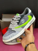 کتونی ترویس اسکات مانستر با طراحی خاص، لوگوی سبز مانستر و ترکیب رنگ جذاب مشکی و سفید.