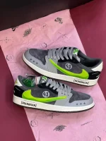 کتونی ترویس اسکات مانستر با طراحی خاص، لوگوی سبز مانستر و ترکیب رنگ جذاب مشکی و سفید.