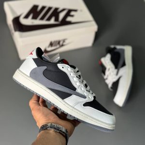 تصویر کتونی ایر جردن 1 ترویس اسکات با رنگ‌بندی طوسی و سفید و لوگوی معکوس نایک