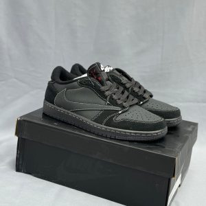 کتونی جردن 1 ترویس اسکات بلک فانتوم با لوگوی معکوس نایکی و رنگ‌بندی مشکی و سفید