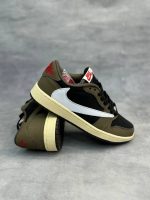 تصویر کتونی ایر جردن 1 ترویس اسکات موکا با رنگ‌بندی قهوه‌ای و سفید و لوگوی معکوس نایک