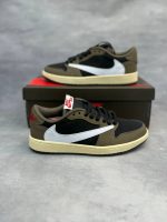 تصویر کتونی ایر جردن 1 ترویس اسکات موکا با رنگ‌بندی قهوه‌ای و سفید و لوگوی معکوس نایک