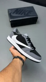 کتونی ایرجردن 1 ترویس اسکات با سوئوش معکوس و رنگ‌بندی مشکی و سفید