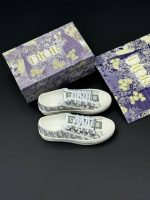 تصویر کتونی دیور سفید طوسی با طراحی کلاسیک و جزئیات لوکس در ترکیب رنگ سفید و سورمهای