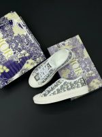 تصویر کتونی دیور سفید طوسی با طراحی کلاسیک و جزئیات لوکس در ترکیب رنگ سفید و سورمهای