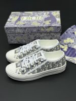 تصویر کتونی دیور سفید طوسی با طراحی کلاسیک و جزئیات لوکس در ترکیب رنگ سفید و سورمه‌ای