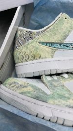 تصویر کتونی نایکی اس بی دراگون با طراحی الهام گرفته از اژدها و جزئیات طلایی و قرمز