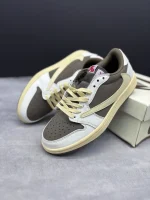 تصویر کتونی ایر جردن 1 ترویس اسکات ریورس موکا با رنگبندی قهوهای و سفید و لوگوی معکوس نایک