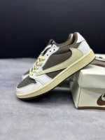 تصویر کتونی ایر جردن 1 ترویس اسکات ریورس موکا با رنگبندی قهوهای و سفید و لوگوی معکوس نایک