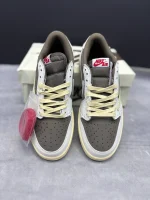 تصویر کتونی ایر جردن 1 ترویس اسکات ریورس موکا با رنگبندی قهوهای و سفید و لوگوی معکوس نایک