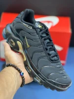 کتونی نایکی تی ان ایرمکس پلاس مشکی طلایی با مش و TPU در پس‌زمینه روشن