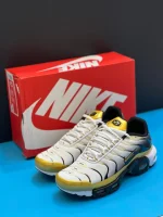 کتونی نایکی تی ان ایرمکس پلاس پریمیوم 50سالگی مشکی و سفید با جزئیات طلایی در پسزمینه روشن