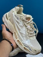 کتونی آف وایت بی رایت بک صورتی قهوهای روشن با مش و جیر و زیپتای نارنجی تو پسزمینه روشن