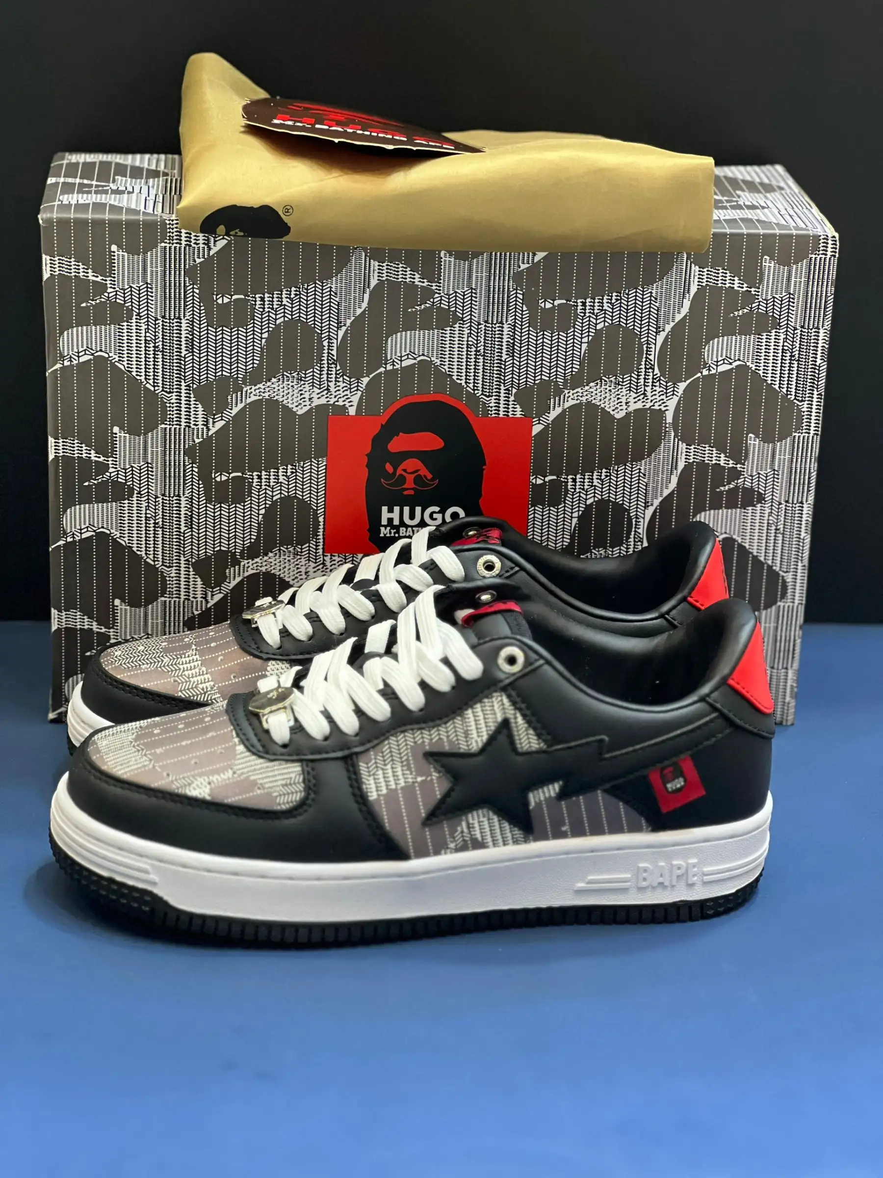 a-bathing-ape-bape-sta (25) کتونی بیپ هیوگو مشکی با چرم براق و لوگوی نقرهای در پسزمینه روشن