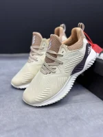 کتونی آدیداس آلفابانس بیاند کرم با مش کرم و زیره BOUNCE™ در پسزمینه روشن