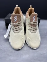 کتونی آدیداس آلفابانس بیاند کرم با مش کرم و زیره BOUNCE™ در پسزمینه روشن