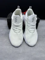 کتونی آدیداس آلفابانس بیاند وایت با مش سفید و زیره BOUNCE™ در پس‌زمینه روشن