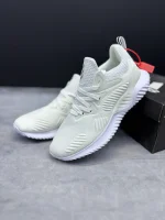 کتونی آدیداس آلفابانس بیاند وایت با مش سفید و زیره BOUNCE™ در پس‌زمینه روشن