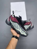 کتونی آدیداس اینتیمیدیشن پکر تک اینک با مش خاکستری و جیر مشکی در پس‌زمینه روشن