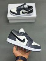 کتونی نایکی جردن 1 لـو متالیک سیلور با چرم خاکستری و درخشش نقره‌ای در پس‌زمینه روشن