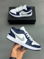 کتونی نایکی جردن 1 لـو میدنایت نِیوی با چرم سفید و روکش‌های آبی تیره در پس‌زمینه روشن