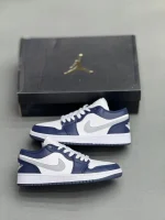 کتونی نایکی جردن 1 لـو میدنایت نِیوی با چرم سفید و روکش‌های آبی تیره در پس‌زمینه روشن