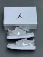 کتونی نایکی جردن 1 لـو متالیک سیلور با چرم خاکستری و درخشش نقرهای در پسزمینه روشن