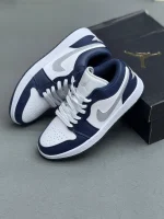 کتونی نایکی جردن 1 لـو میدنایت نِیوی با چرم سفید و روکش‌های آبی تیره در پس‌زمینه روشن