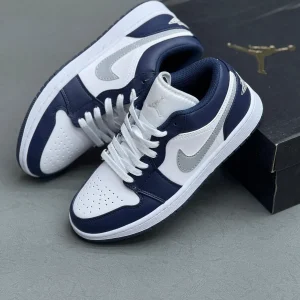 کتونی نایکی جردن 1 لـو میدنایت نِیوی با چرم سفید و روکش‌های آبی تیره در پس‌زمینه روشن