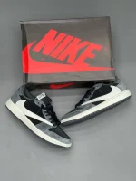 کتونی نایکی جردن 1 لـو ترویس اسکات خاکستری با چرم سفید و جیر خاکستری در پسزمینه روشن