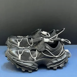 کتونی بالنسیاگا هایک مشکی با مش تیره و افکت کهنه در پس‌زمینه روشن