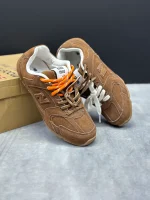 کتونی نیوبالانس میو میو قهوه‌ای با چرم و جیر در پس‌زمینه روشن