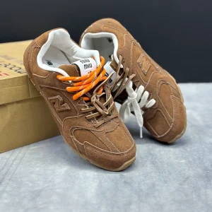 کتونی نیوبالانس میو میو قهوه‌ای با چرم و جیر در پس‌زمینه روشن