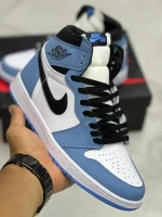 کتونی نایکی جردن 1 های یونیورسیتی بلو با چرم سفید و روکشهای آبی در پسزمینه روشن