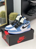 کتونی نایکی جردن 1 های یونیورسیتی بلو با چرم سفید و روکشهای آبی در پسزمینه روشن