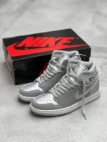 کتونی نایکی جردن 1 های Neutral Gray با چرم سفید و روکشهای خاکستری در پسزمینه روشن