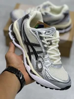 کتونی اسیکی ژل-کایانو 14 اویستر وایت/استیپل گری با مش سفید و روکش‌های خاکستری در پس‌زمینه روشن