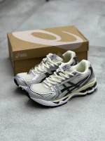 کتونی اسیکی ژل-کایانو 14 اویستر وایت/استیپل گری با مش سفید و روکش‌های خاکستری در پس‌زمینه روشن