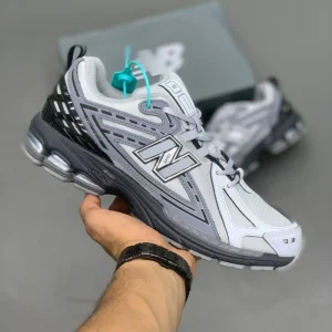 کتونی نیوبالانس 1906R برایتون گری با مش خاکستری و روکش‌های براق در پس‌زمینه روشن