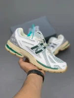 کتونی نیوبالانس 1906R وایت گرین کرم با مش سفید و روکشهای سبز در پسزمینه روشن