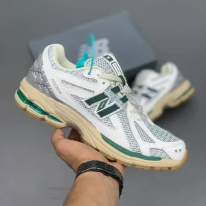 کتونی نیوبالانس 1906R وایت گرین کرم با مش سفید و روکش‌های سبز در پس‌زمینه روشن