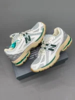 کتونی نیوبالانس 1906R وایت گرین کرم با مش سفید و روکشهای سبز در پسزمینه روشن