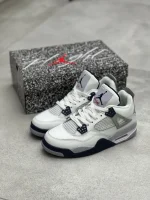 کتونی نایکی جردن 4 میدنایت نِیوی با چرم سفید و روکش‌های آبی تیره در پس‌زمینه روشن