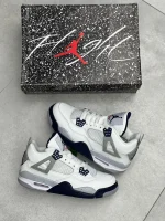 کتونی نایکی جردن 4 میدنایت نِیوی با چرم سفید و روکش‌های آبی تیره در پس‌زمینه روشن