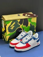 کتونی A Bathing Ape Bapesta وایت بلو رد با چرم سفید و روکشهای آبی و قرمز در پسزمینه روشن