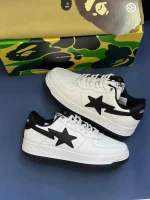 کتونی A Bathing Ape Bapesta x JJJJound وایت نوی با چرم سفید و روکش‌های آبی در پس‌زمینه روشن