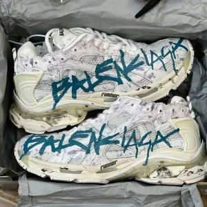 کتونی بالنسیاگا رانر گرافیتی وایت بلو با مش سفید و الگوی آبی در پسزمینه روشن