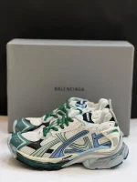 کتونی بالنسیاگا رانر وایت گرین بلو با مش سفید و الگوی گرافیتی در پس‌زمینه روشن